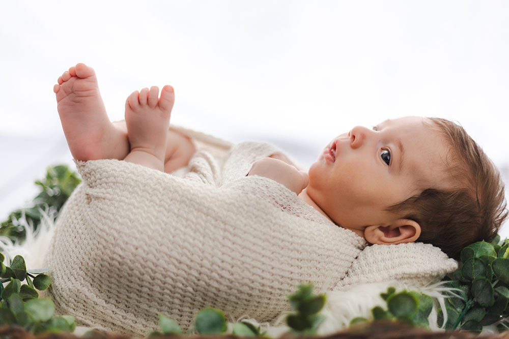 bébé éveillé dans un lange dans panier fleuri lisa mazeau photographe professionnelle gironde