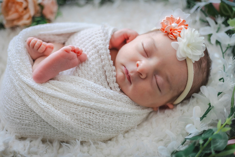 petit bébé emmailloté et fleur cheveux lisa mazeau photographe professionnelle gironde