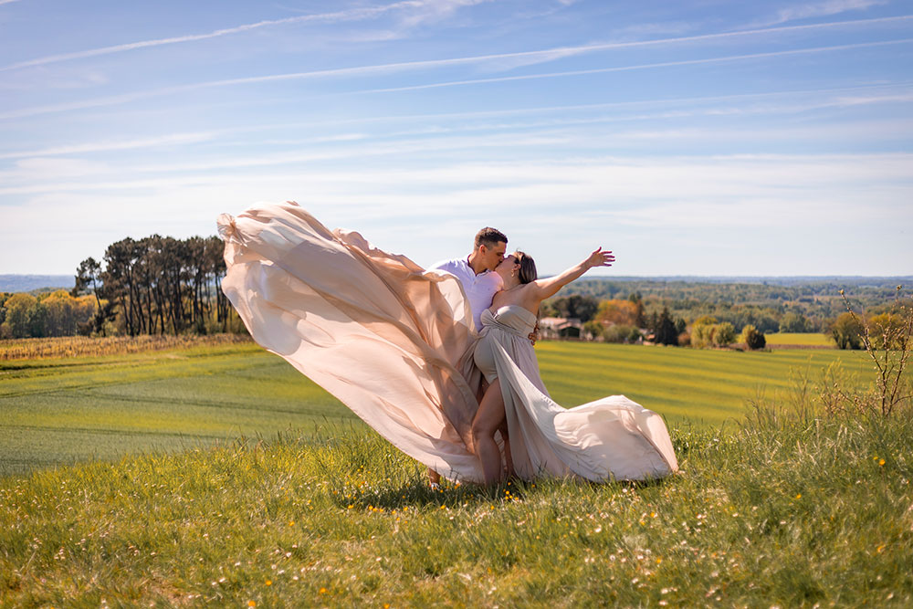 femme enceinte et papa qui s'embrassent robe qui vole lisa mazeau photographe professionnelle gironde