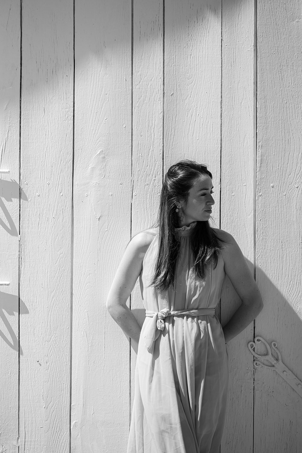 portrait en noir et blanc de la photographe lisa mazeau avec robe longue qui tourne la tête lisa mazeau photographe professionnelle gironde