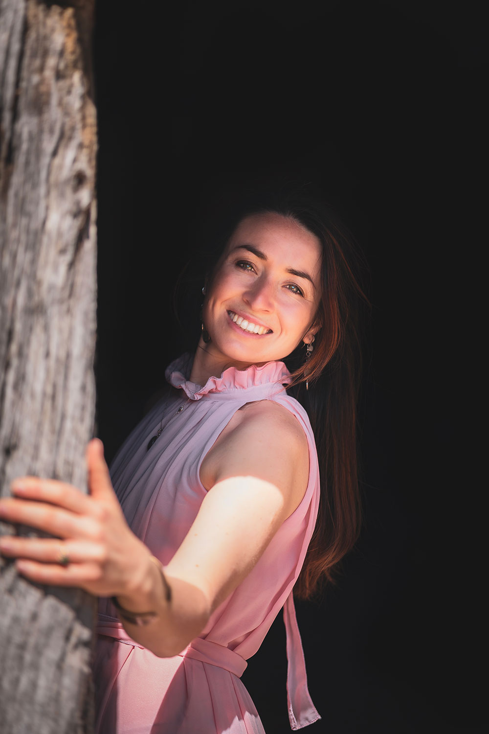 sublime portrait de la photographe lisa mazeau en clair obscur avec une robe rose et sourire
