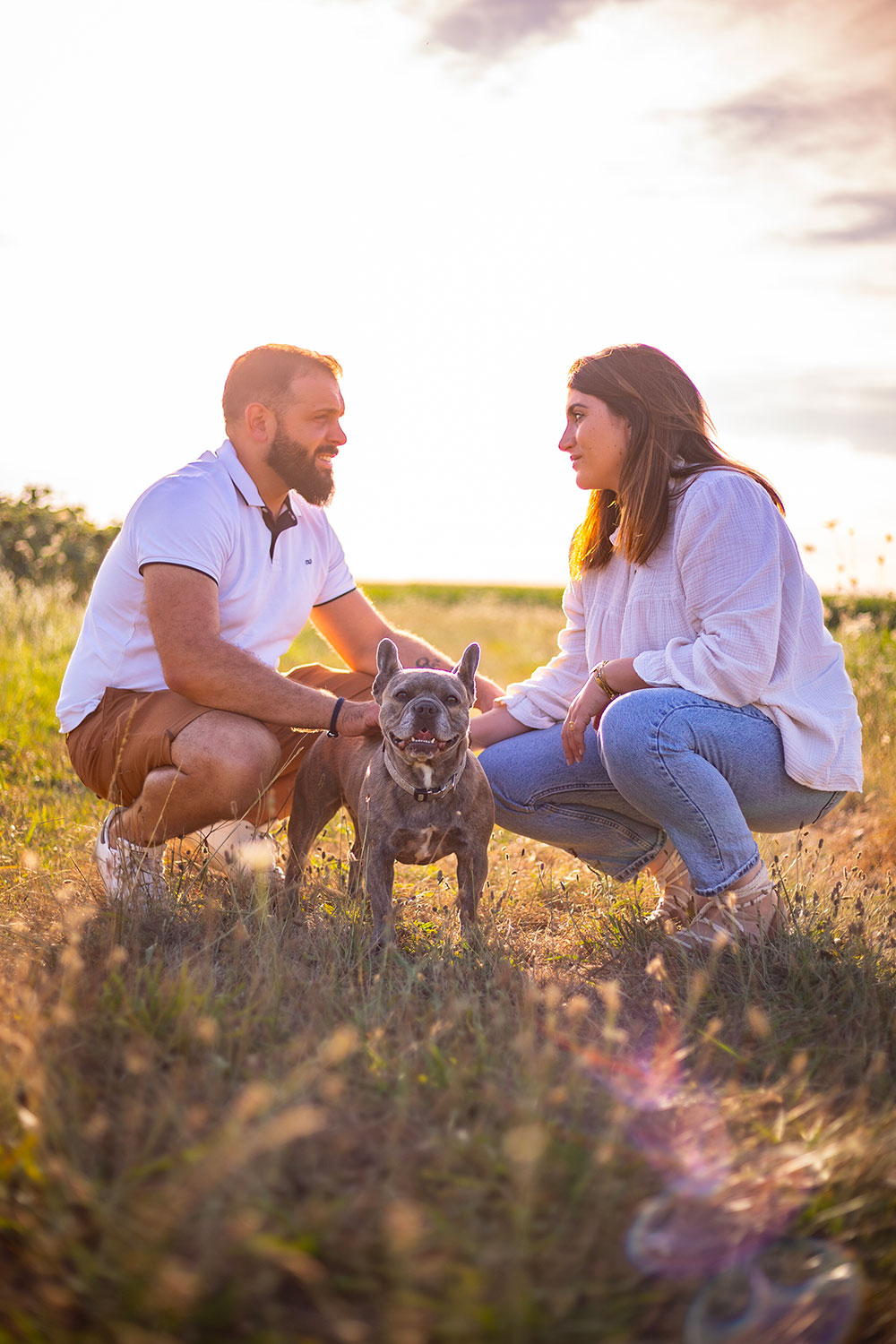 portrait de chien boxer dans champ de fleurs avec homme et femme qui se regardent lisa mazeau photographe professionnelle gironde