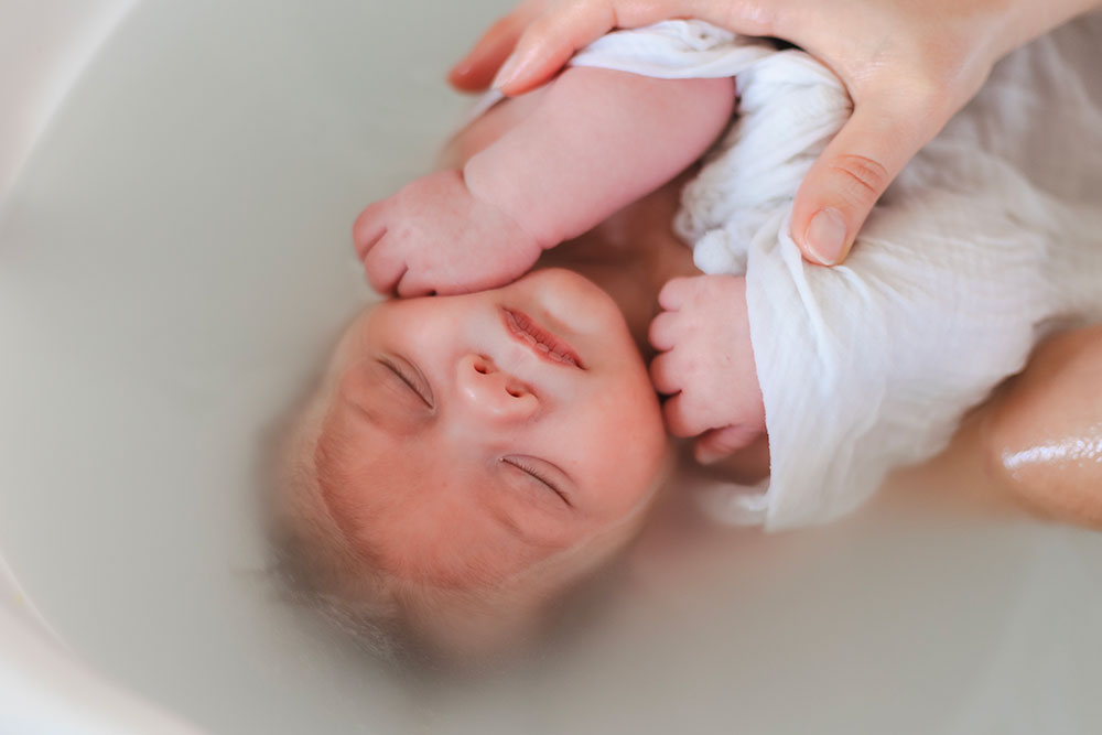 bébé dans eau petite main bain enveloppé lisa mazeau photographe professionnelle gironde