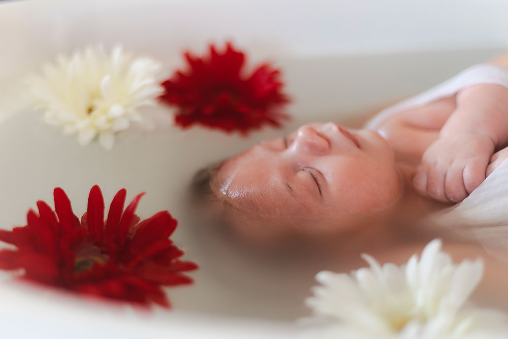 bébé flotte dans eau et fleur couleur bain enveloppé lisa mazeau photographe professionnelle gironde