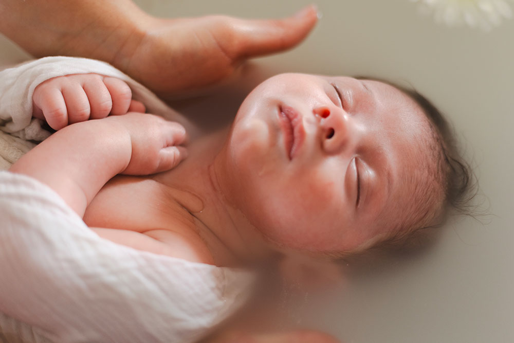 tenir un bébé dans un bain enveloppé lisa mazeau photographe professionnelle gironde