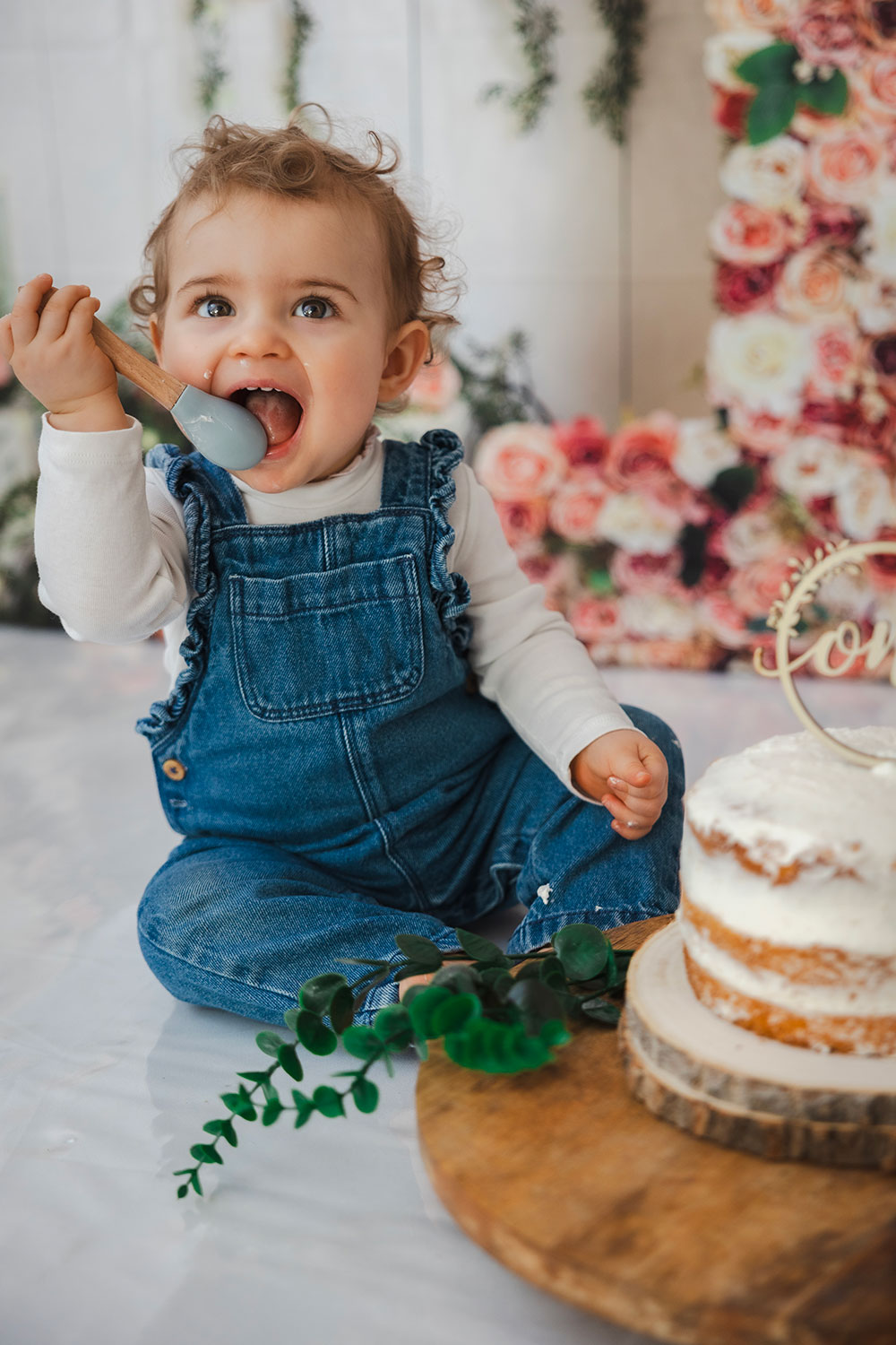bébé qui sourit en salopette mange sa cuillère lisa mazeau photographe professionnelle gironde