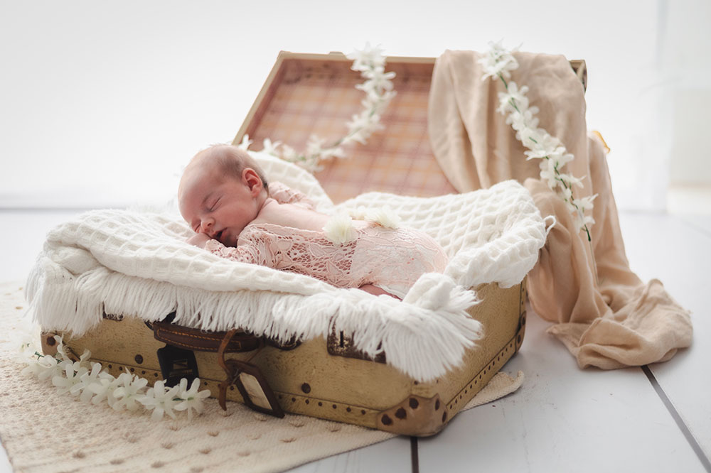 bébé avec petit body rose dentelle dans une valise lisa mazeau photographe professionnelle gironde