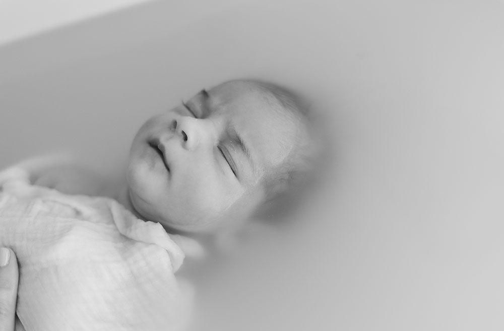 bébé concentré dans un bain enveloppé noir et blanc lisa mazeau photographe professionnelle gironde