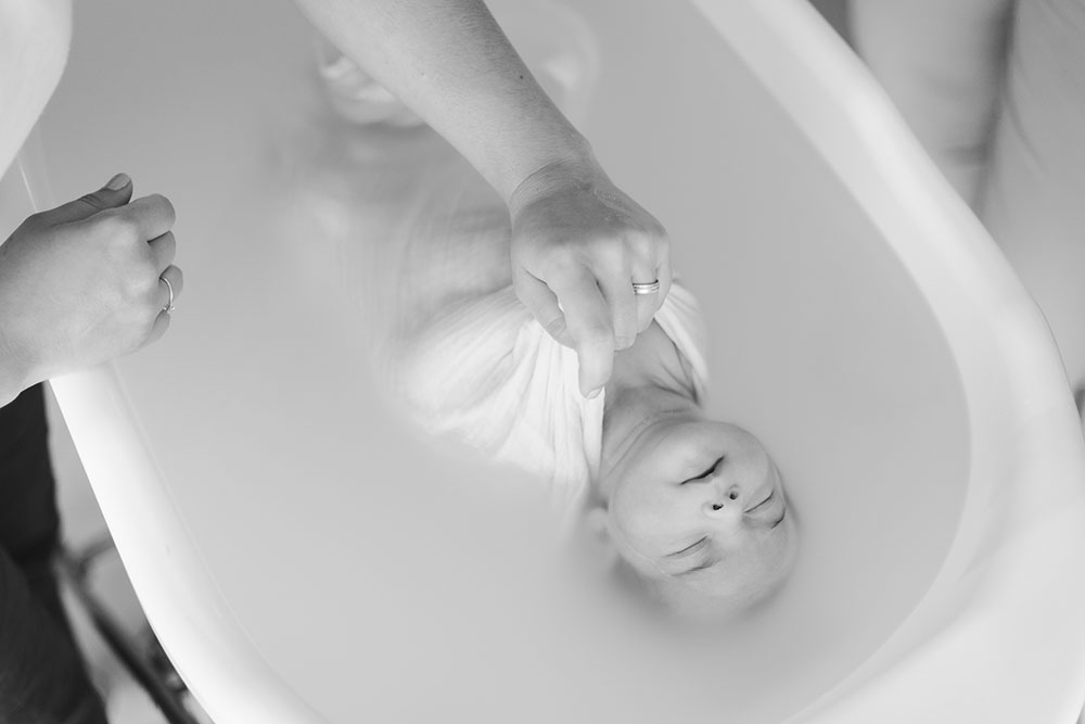 retenir bébé dans un bain enveloppé noir et blanc lisa mazeau photographe professionnelle gironde