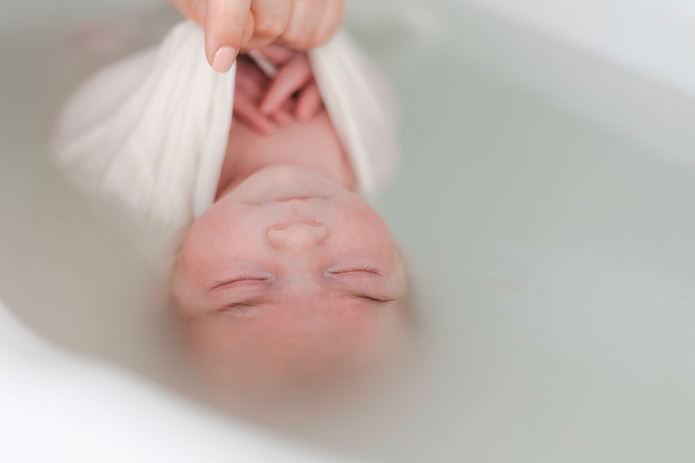 retenir bébé dans un bain enveloppé lisa mazeau photographe professionnelle gironde