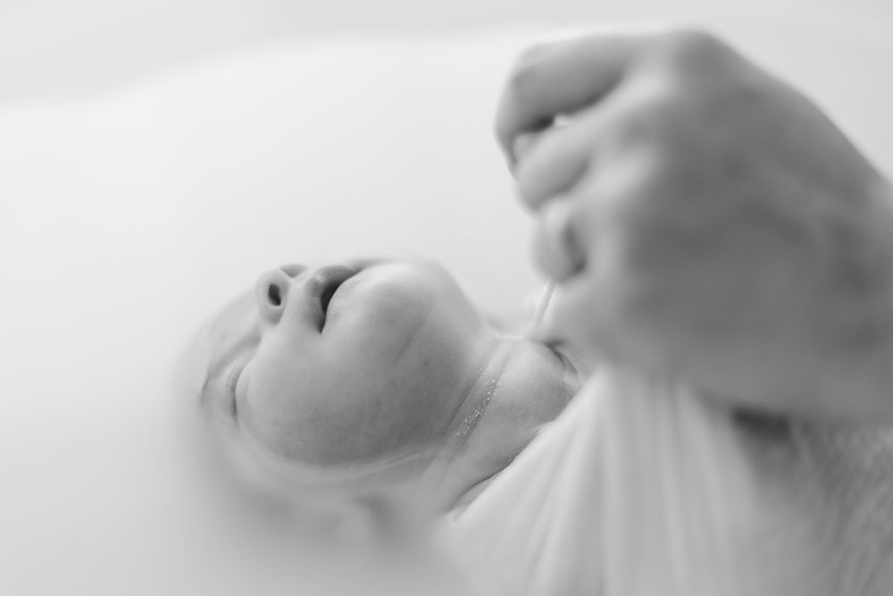 main et bébé dans un bain enveloppé lisa mazeau photographe professionnelle gironde