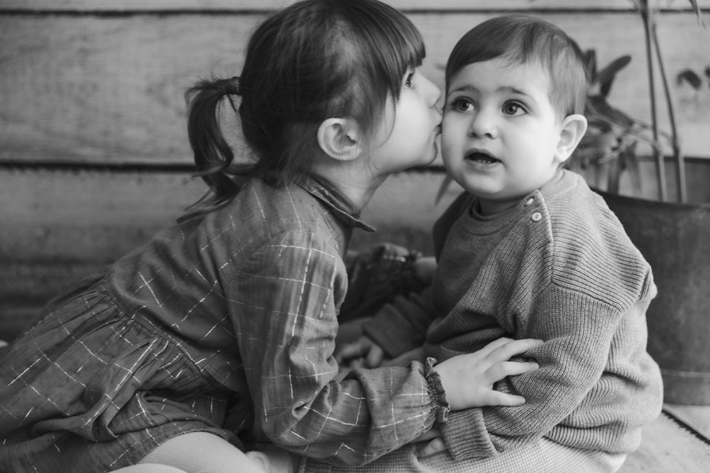 petite fille fait un bisou à sa soeur lisa mazeau photographe professionnelle gironde