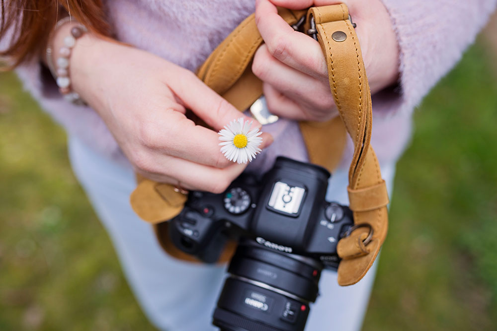 gros plan sur la photographe lisa mazeau de son appareil photo avec une pâquerette