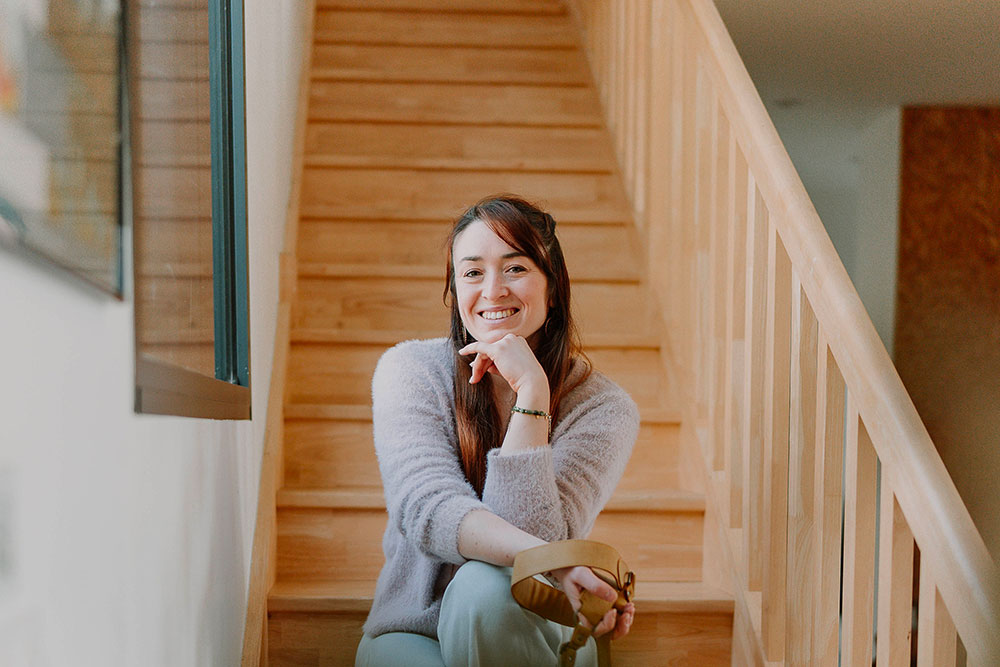 photo de la photographe lisa mazeau qui sourie assise sur un escalier